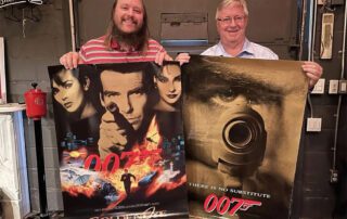 Nikolai Adams (left) with a Goldeneye theatrical poster, and Sean Adams with a Goldeneye advance poster.